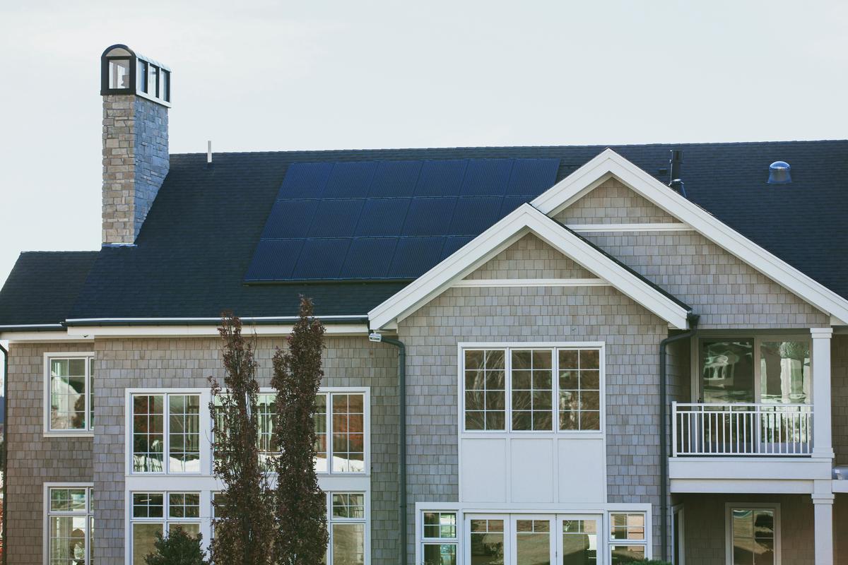 Illustration of a solar panel system on a rental property with tenants enjoying reduced utility bills and contributing to environmentally-friendly practices.